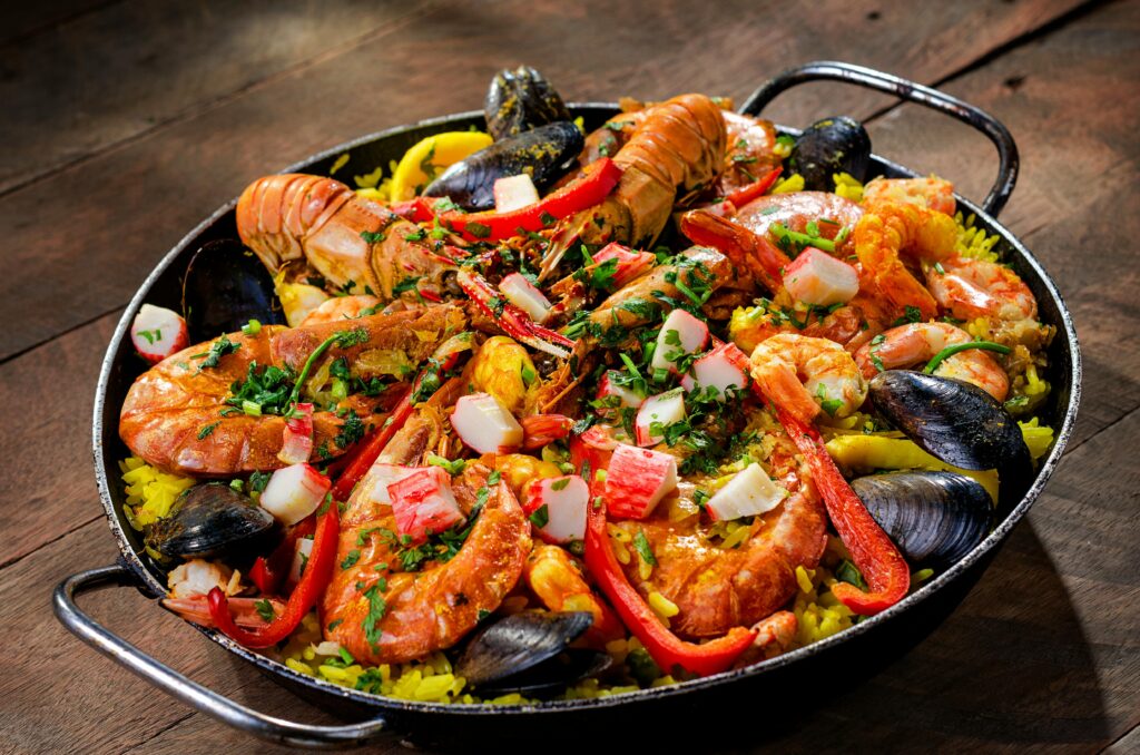 Colorful seafood paella with shrimp, mussels, and rice in a traditional pan.