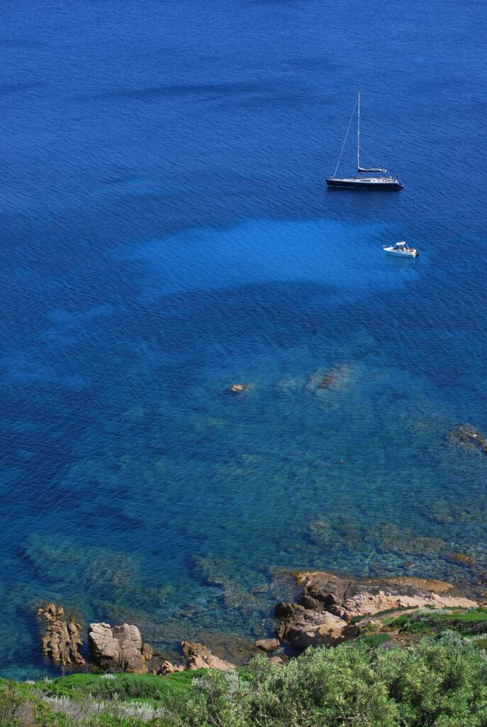 A tranquil view of sailboats floating on the clear blue waters off the coast of Ajaccio, Corse, France.
